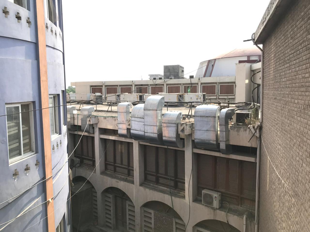 Workers on scaffolding installing duct